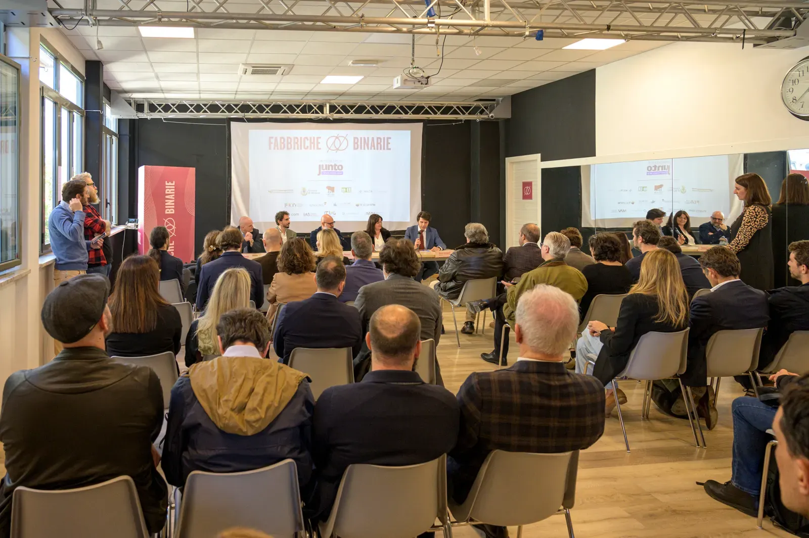 Un evento negli spazi di Fabbriche Binarie: platea e relatori davanti allo schermo