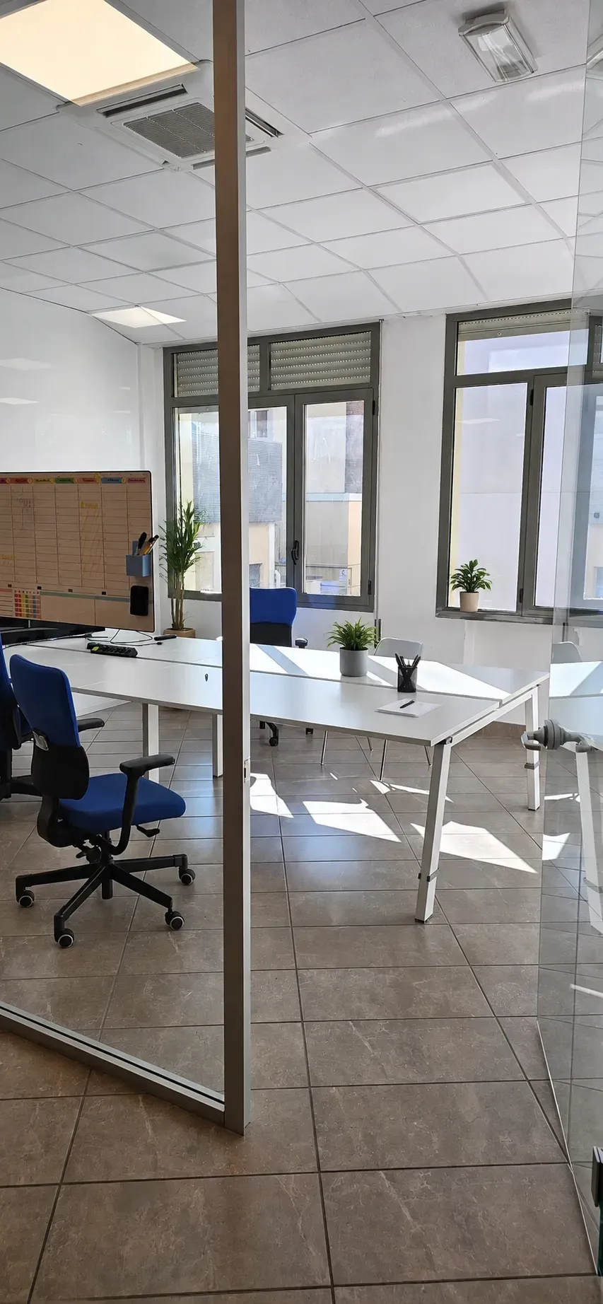 Sala riunioni con pareti in vetro, scrivania e sedie